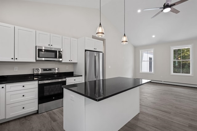 kitchen featuring appliances with stainless steel finishes, white cabinetry, dark hardwood / wood-style flooring, hanging light fixtures, and a center island