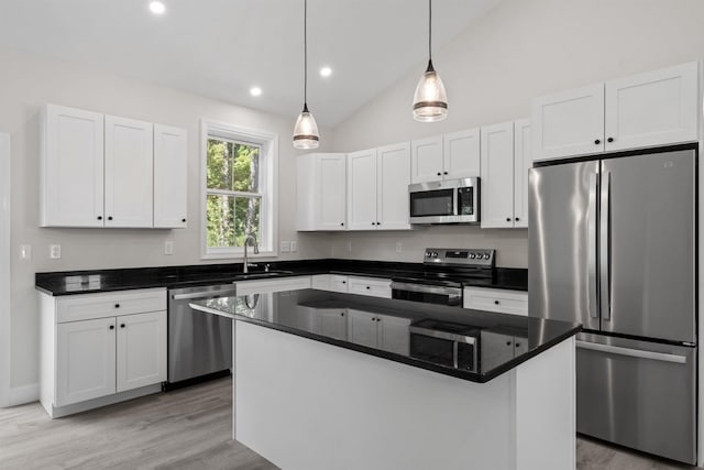 kitchen featuring sink, a center island, hanging light fixtures, appliances with stainless steel finishes, and white cabinets