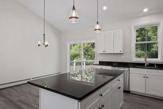 kitchen with hanging light fixtures, white cabinetry, a center island, and sink