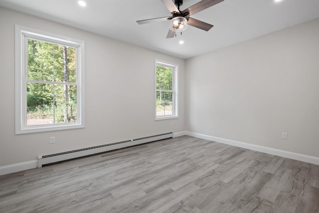 spare room with a baseboard radiator, ceiling fan, and light hardwood / wood-style floors