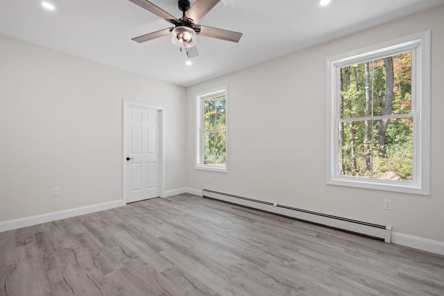 unfurnished room featuring light wood-type flooring, ceiling fan, and baseboard heating