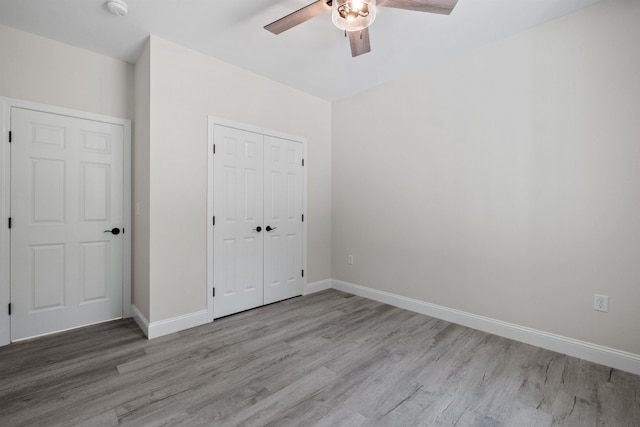 unfurnished bedroom with ceiling fan, a closet, and light hardwood / wood-style flooring