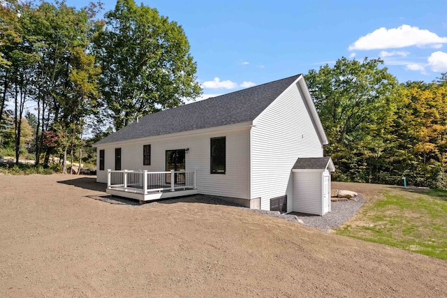 exterior space with a storage shed, a deck, and a front yard