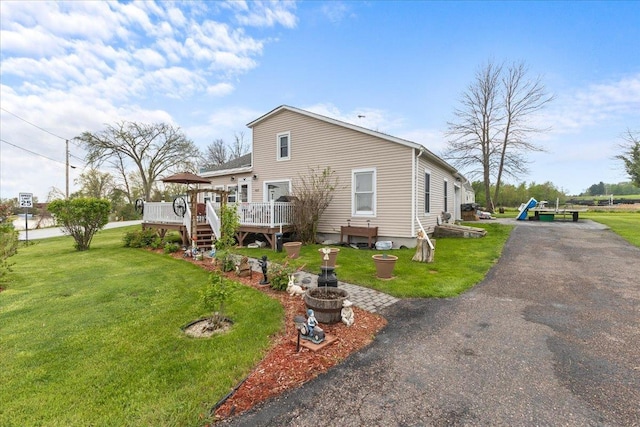 back of house featuring a yard and a deck