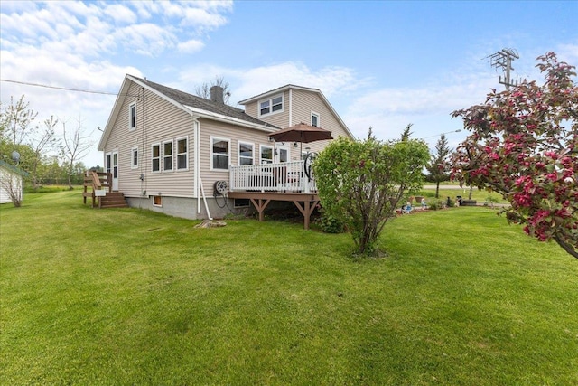 rear view of house featuring a wooden deck and a yard