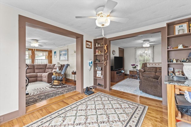 living room featuring ornamental molding, a healthy amount of sunlight, and light hardwood / wood-style floors