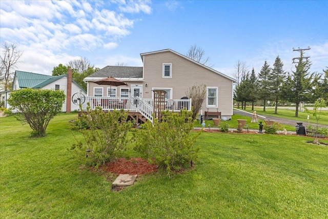 rear view of property featuring a yard and a deck