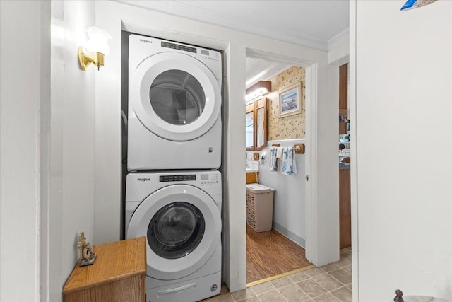 laundry area with tile walls, stacked washer / drying machine, and ornamental molding