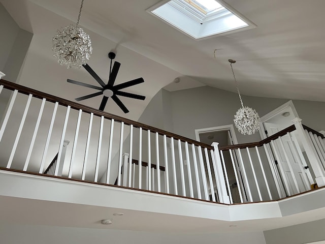 stairway with a skylight, high vaulted ceiling, and a notable chandelier