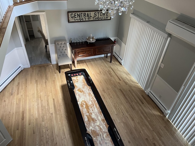 interior space featuring hardwood / wood-style flooring, a baseboard radiator, and a chandelier