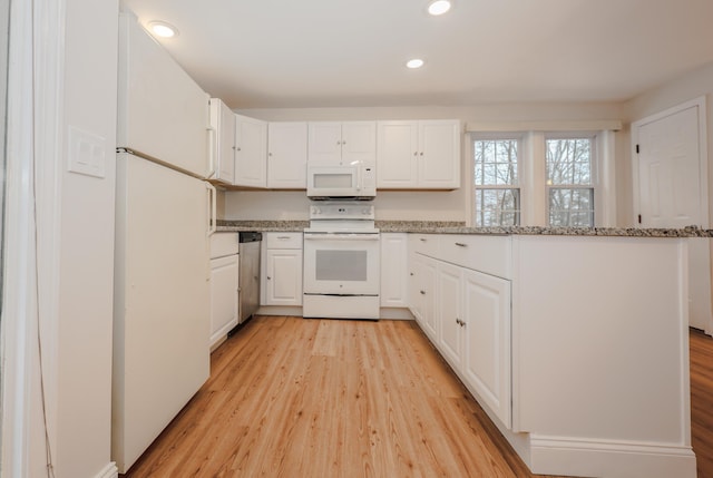 kitchen featuring white cabinetry, white appliances, light hardwood / wood-style floors, and light stone counters