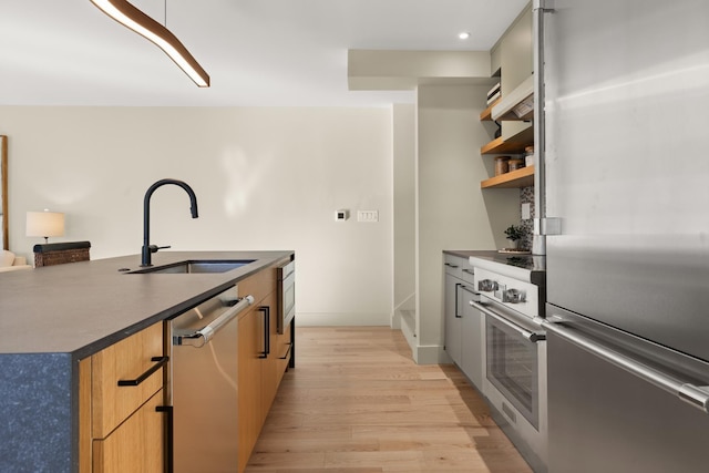 kitchen featuring appliances with stainless steel finishes, sink, and light wood-type flooring