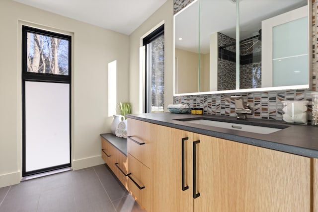 bathroom with vanity, backsplash, tile patterned flooring, and plenty of natural light