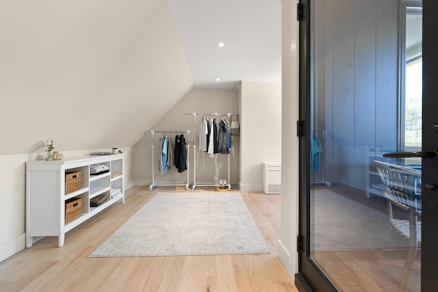 interior space featuring lofted ceiling and light hardwood / wood-style flooring