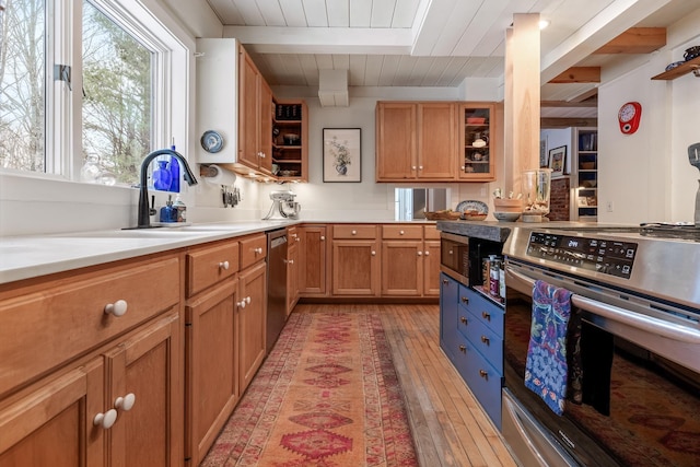 kitchen with appliances with stainless steel finishes, beamed ceiling, sink, light hardwood / wood-style floors, and wooden ceiling