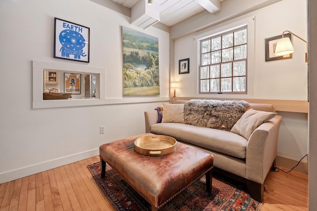 sitting room with beamed ceiling and hardwood / wood-style floors