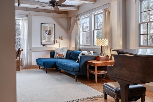 living area with ceiling fan, beam ceiling, and light hardwood / wood-style floors