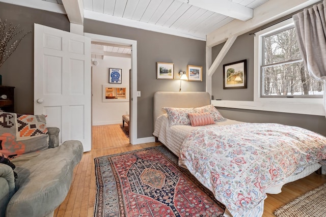 bedroom featuring wood ceiling, hardwood / wood-style flooring, and beamed ceiling