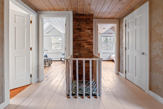 corridor featuring wood ceiling, light hardwood / wood-style flooring, and a wealth of natural light