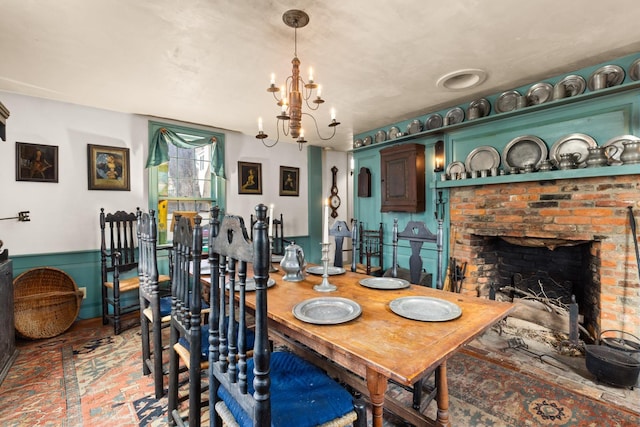 dining area featuring an inviting chandelier and a fireplace