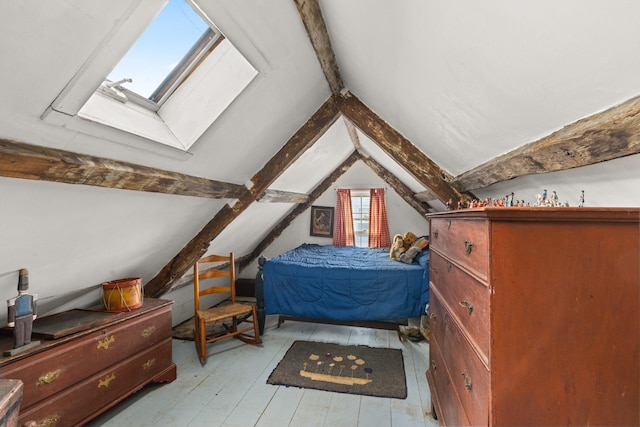 bedroom featuring vaulted ceiling with skylight and light hardwood / wood-style floors