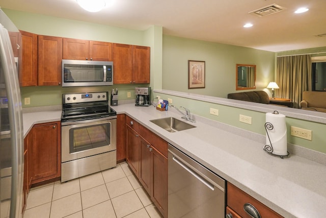 kitchen featuring light tile patterned flooring, appliances with stainless steel finishes, sink, and kitchen peninsula