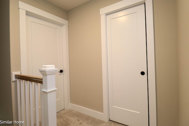 hallway featuring light colored carpet