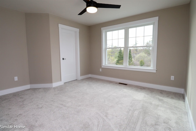 carpeted spare room with ceiling fan