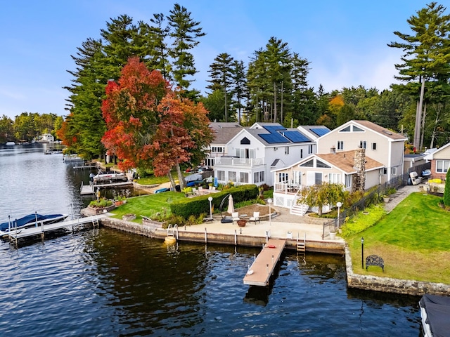 exterior space with a water view, a patio area, and a lawn