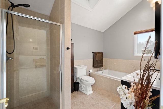 bathroom with tile patterned flooring, tile walls, lofted ceiling with skylight, separate shower and tub, and toilet