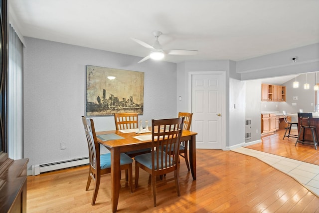 dining space with a baseboard radiator, ceiling fan, and light hardwood / wood-style floors