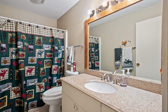 bathroom featuring tile patterned flooring, vanity, and toilet