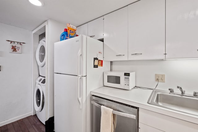 kitchen featuring sink, white cabinets, dark hardwood / wood-style flooring, stacked washer / drying machine, and white appliances