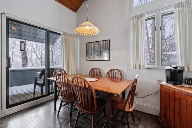 dining space with high vaulted ceiling and dark hardwood / wood-style flooring