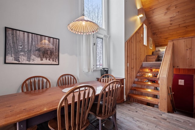 dining area with light hardwood / wood-style floors and a high ceiling