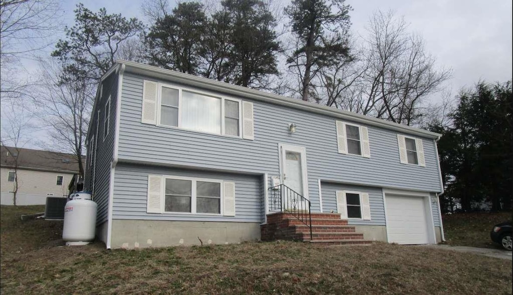 raised ranch with a garage and central air condition unit