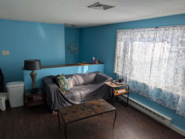 bedroom featuring multiple windows, dark hardwood / wood-style flooring, and baseboard heating