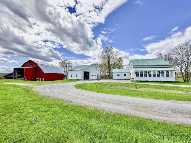 view of front facade with an outbuilding, a garage, and a front yard