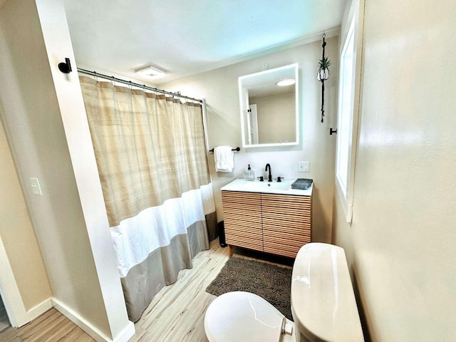 bathroom featuring vanity, hardwood / wood-style flooring, curtained shower, and toilet