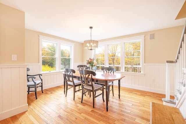 dining space with a notable chandelier and light hardwood / wood-style floors