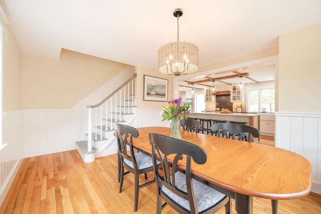 dining room with light hardwood / wood-style flooring and a notable chandelier