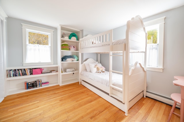 bedroom with a baseboard radiator and wood-type flooring