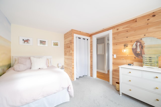 bedroom featuring light carpet and wood walls