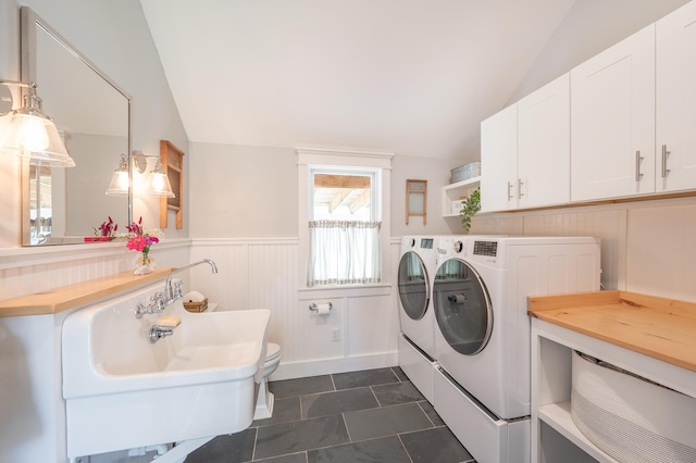 clothes washing area featuring dark tile patterned flooring, sink, and washer and dryer