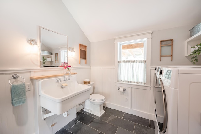 bathroom featuring independent washer and dryer, lofted ceiling, toilet, and tile patterned flooring