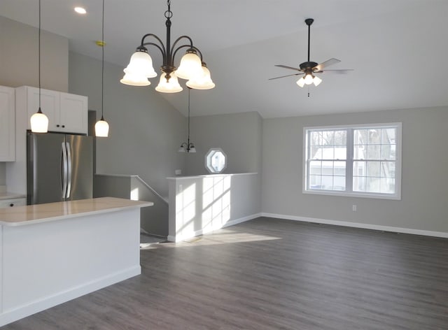 kitchen with white cabinetry, decorative light fixtures, high vaulted ceiling, dark hardwood / wood-style floors, and stainless steel fridge