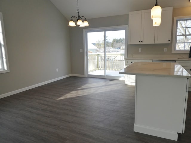 kitchen featuring pendant lighting, lofted ceiling, white cabinetry, dark hardwood / wood-style floors, and a kitchen island