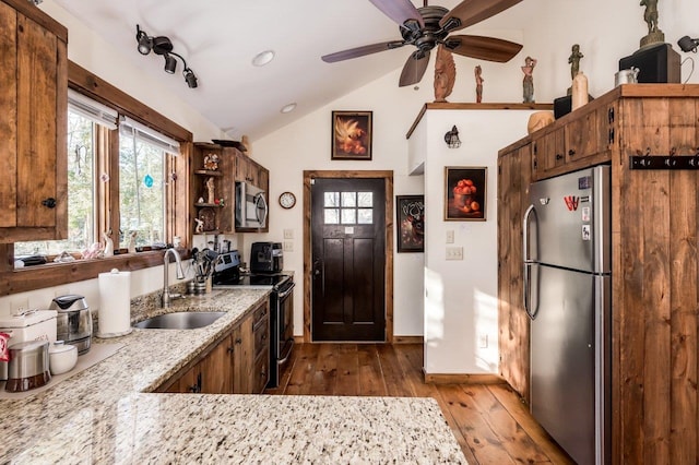 kitchen featuring vaulted ceiling, a healthy amount of sunlight, appliances with stainless steel finishes, and sink