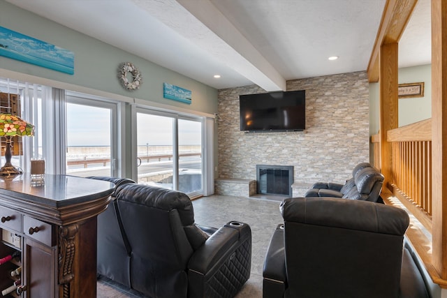 living room featuring a stone fireplace and beam ceiling