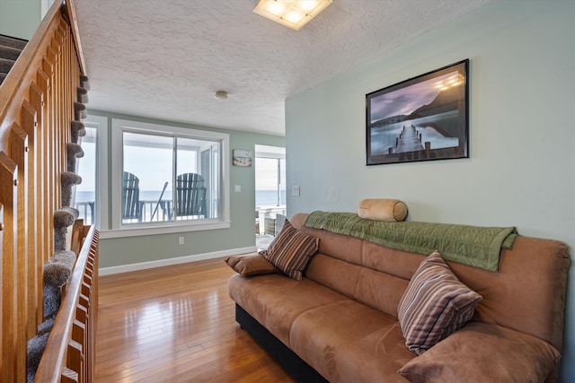 living room featuring a textured ceiling and light wood-type flooring